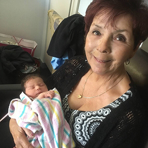 Margaret sitting with her new grandchild
