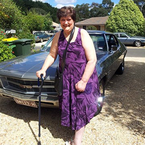 maryanne next to her car with her cane 