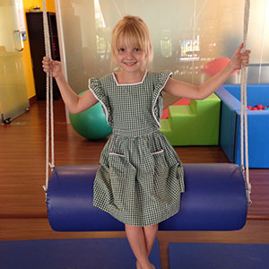 Imogen on a swing at rehab