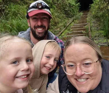 A family pose in front of bushy stairs