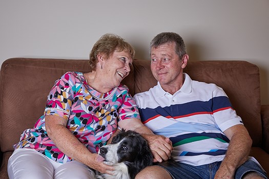 Warren and his wife on the couch at home